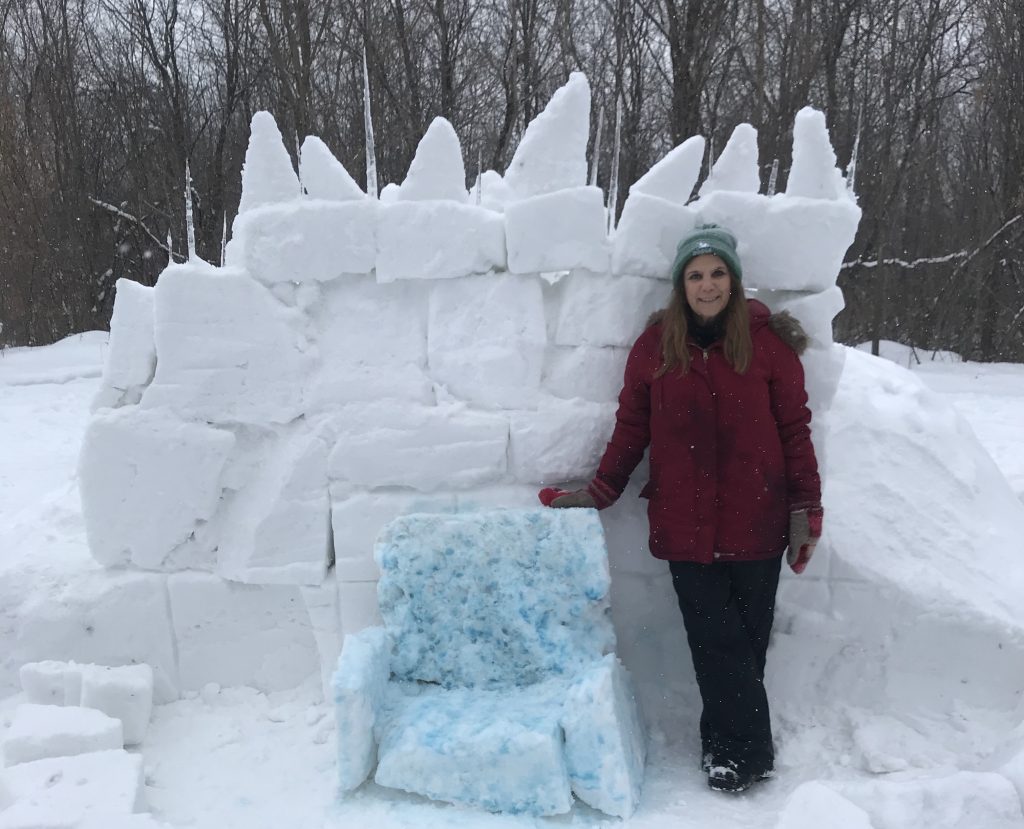 Dodge Nature Center Naturalist Pam Welisevich with an ice palace constructed for a Frozen-themed program.