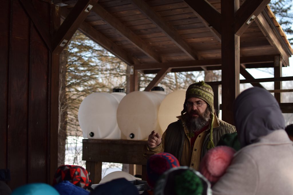 Dodge Nature Center Naturalist Mick leads a group of students on making maple syrup.